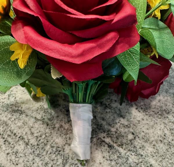Up close of red rose and hand tied bouquet.